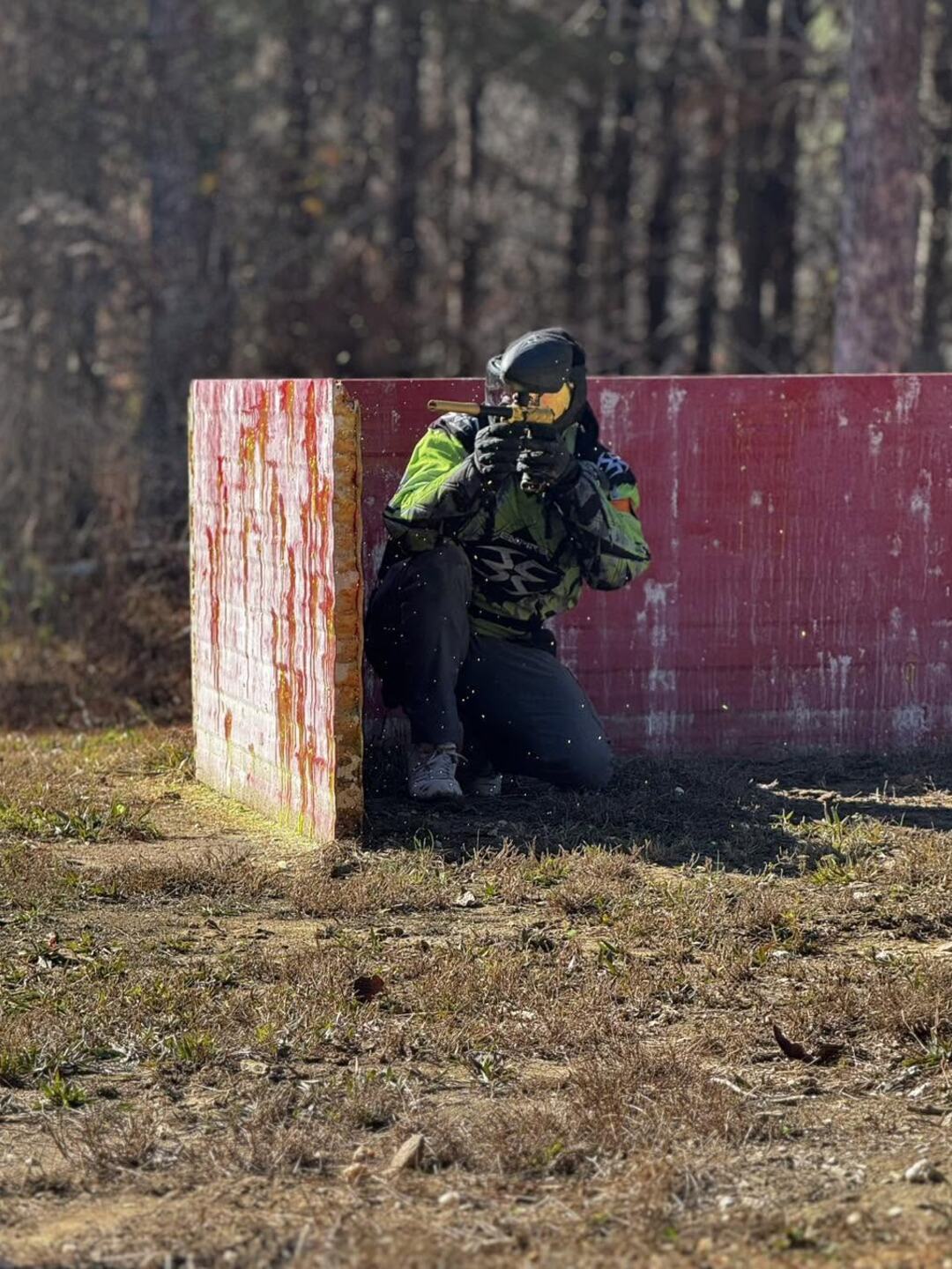 Paintball player taking cover behind a bunker in the Tallapoosa woods